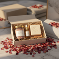 Curated bath and body gift box with floral bath salts, soap and oil surrounded by dried roses